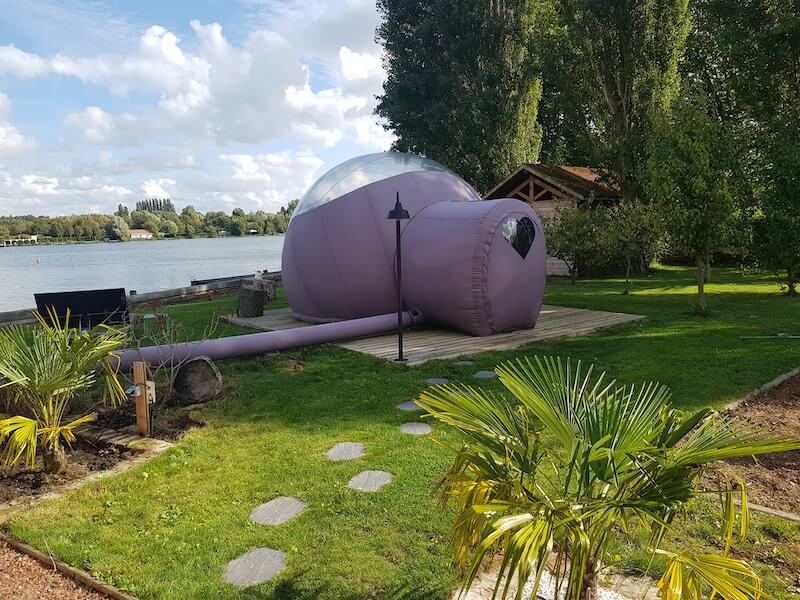 Vue arrière d'une chambre bulle avec vue sur le lac