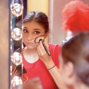 Danseuse en pleine séance de maquillage en coulisses